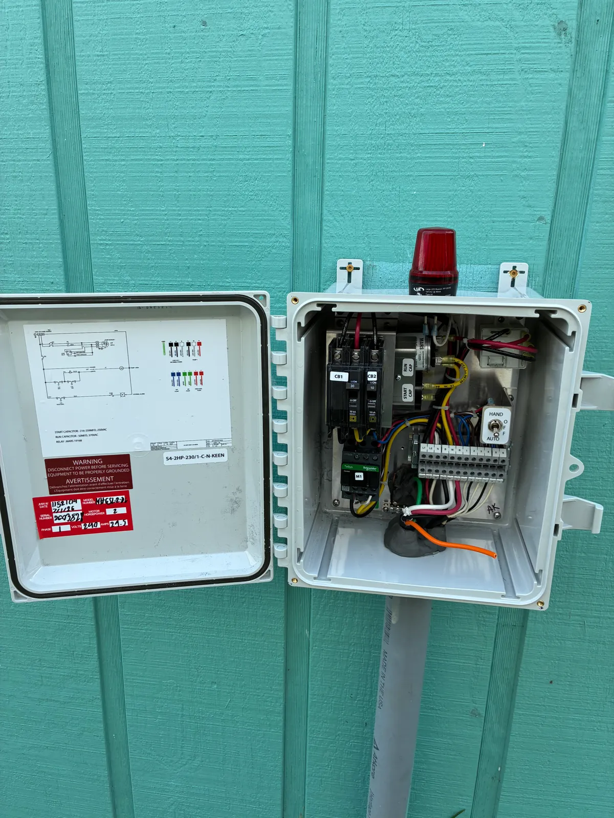 Commercial pump control panel wired inside an outdoor NEMA enclosure, with breakers, terminal blocks, and an alarm light